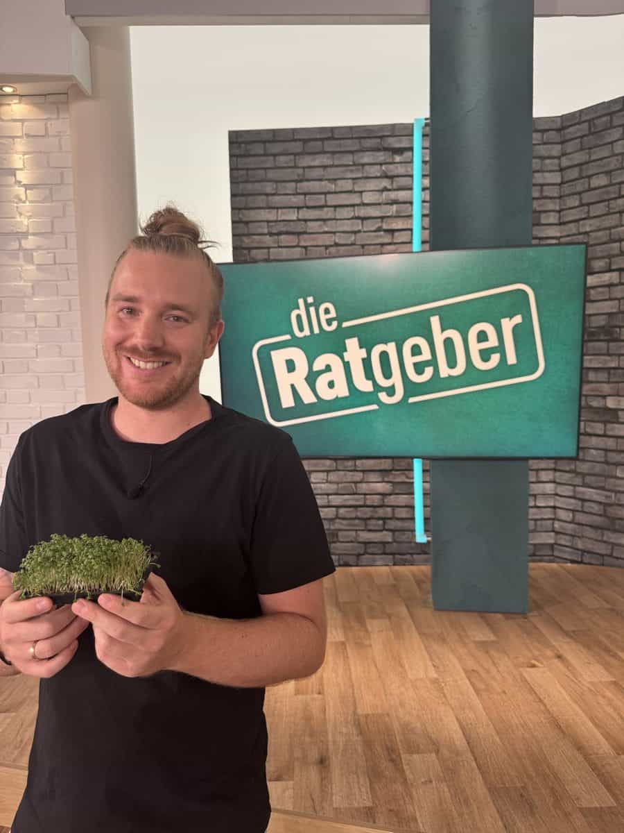 Benne Benzing mit frischer Kresse vor dem Studio-Schild der HR-Sendung „Die Ratgeber“