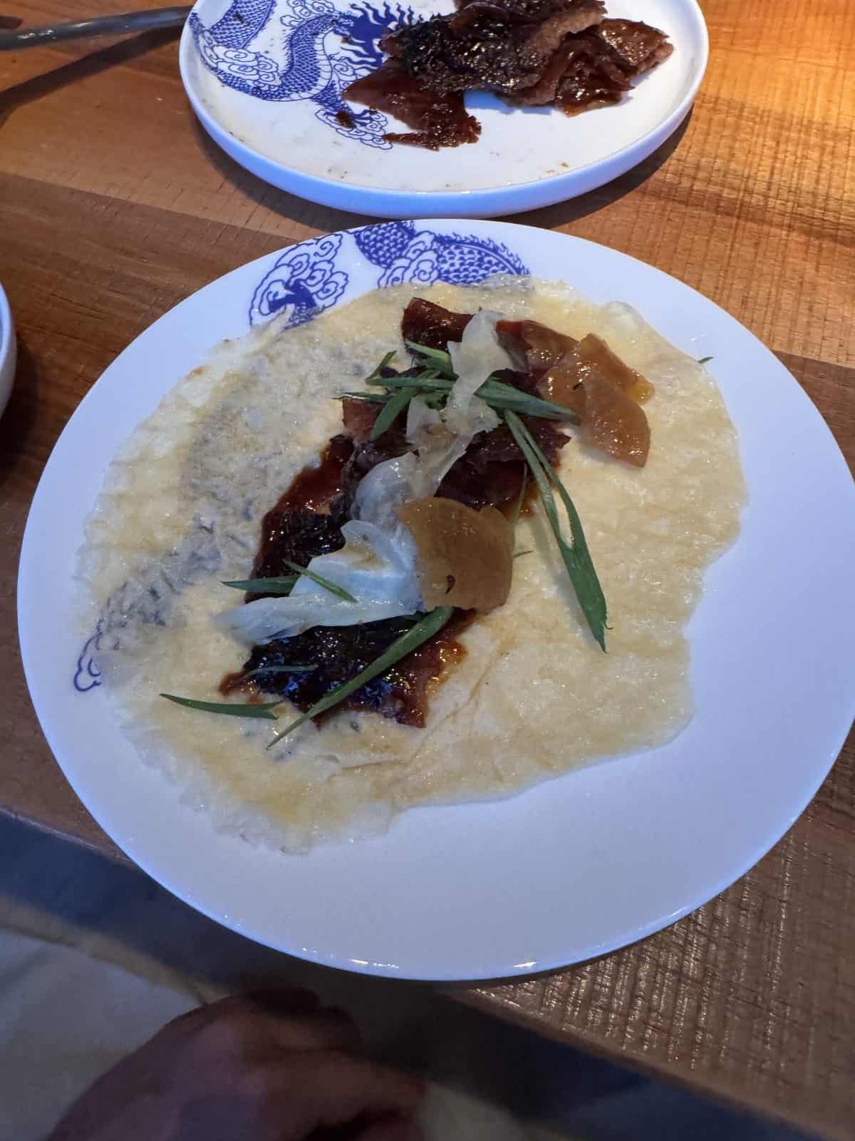 Selbst gerollter Pfannkuchen mit knuspriger Entenhaut, Hoisin, Frühlingszwiebeln und eingelegtem Gemüse im Orania Berlin