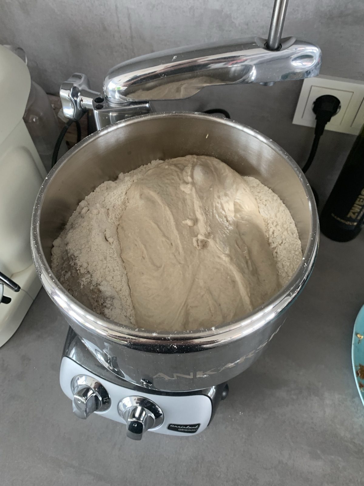 Teig aus Mehl und Wasser in der drehenden Edelstahlschüssel der Ankarsrum