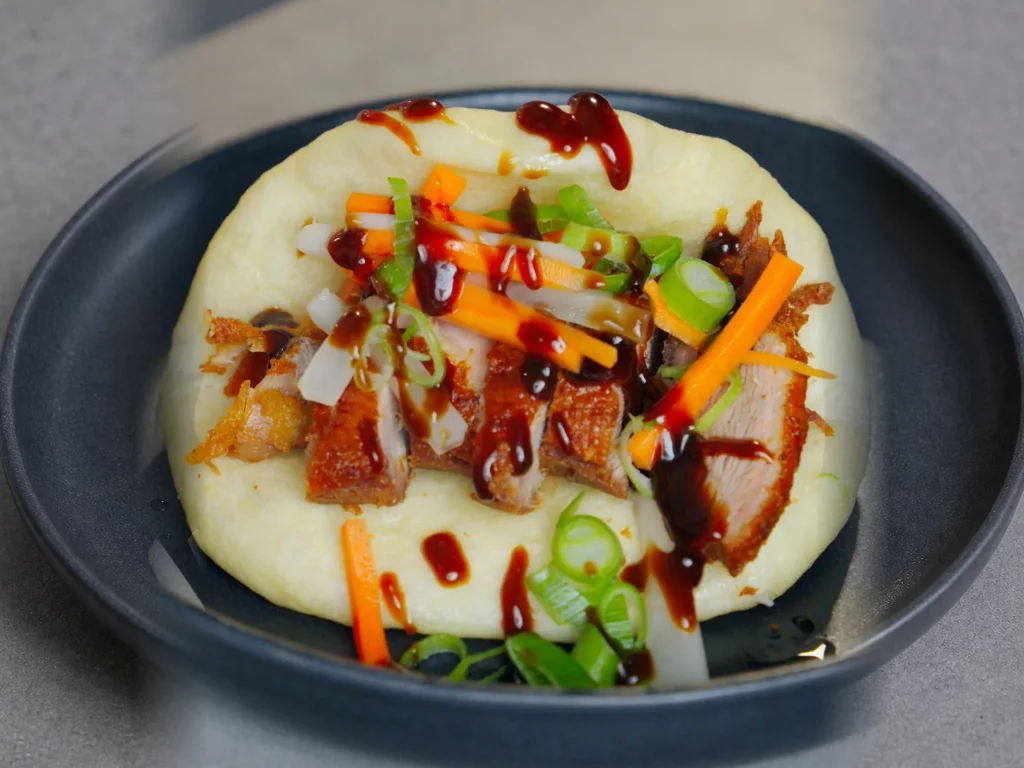 Bao Bun mit knuspriger Ente, eingelegtem Gemüse und Hoisinsauce