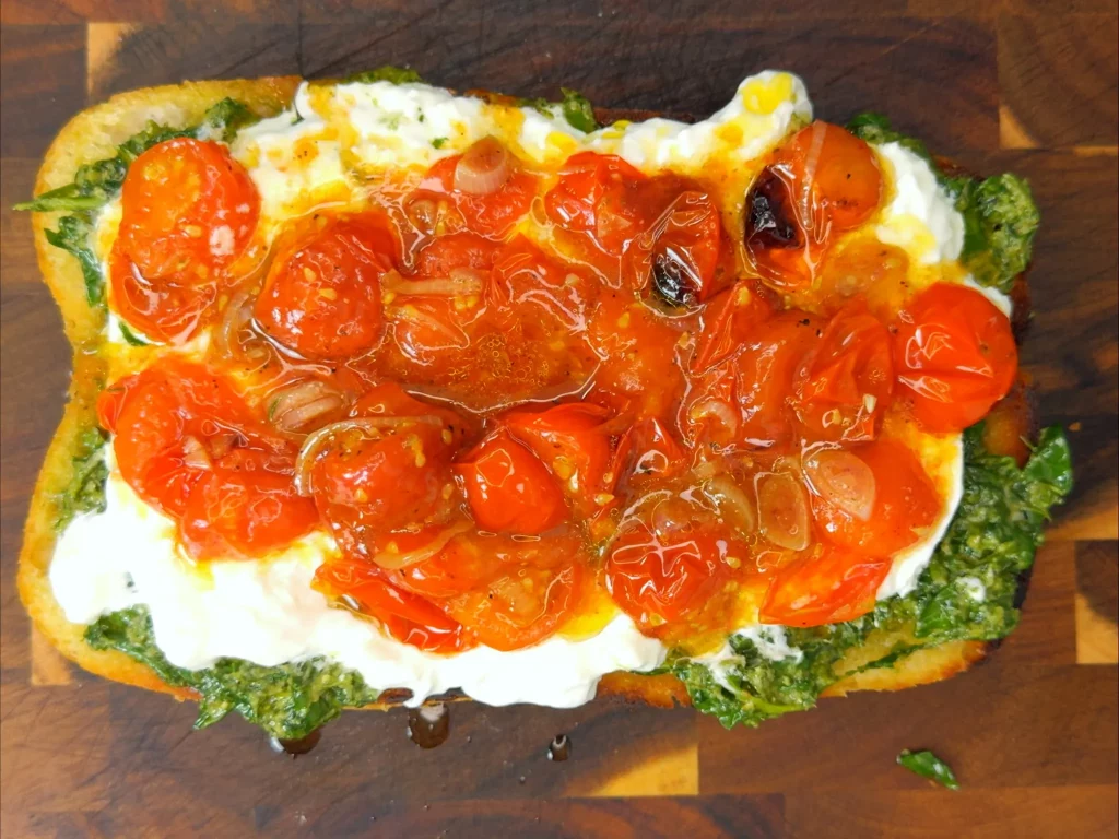Burrata Sandwich – offenes Ciabatta mit Basilikumpesto, cremiger Burrata und confierten Kirschtomaten, von oben