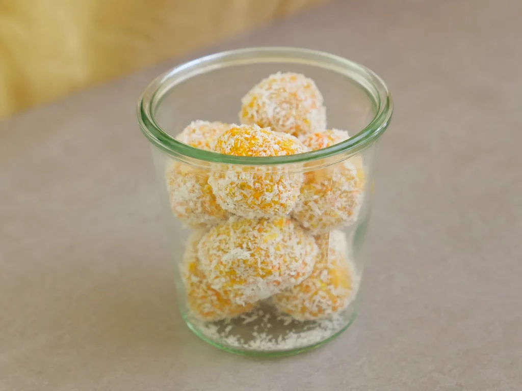 Carrot Cake Energy Balls – im Glas gestapelt, mit Kokosraspeln paniert