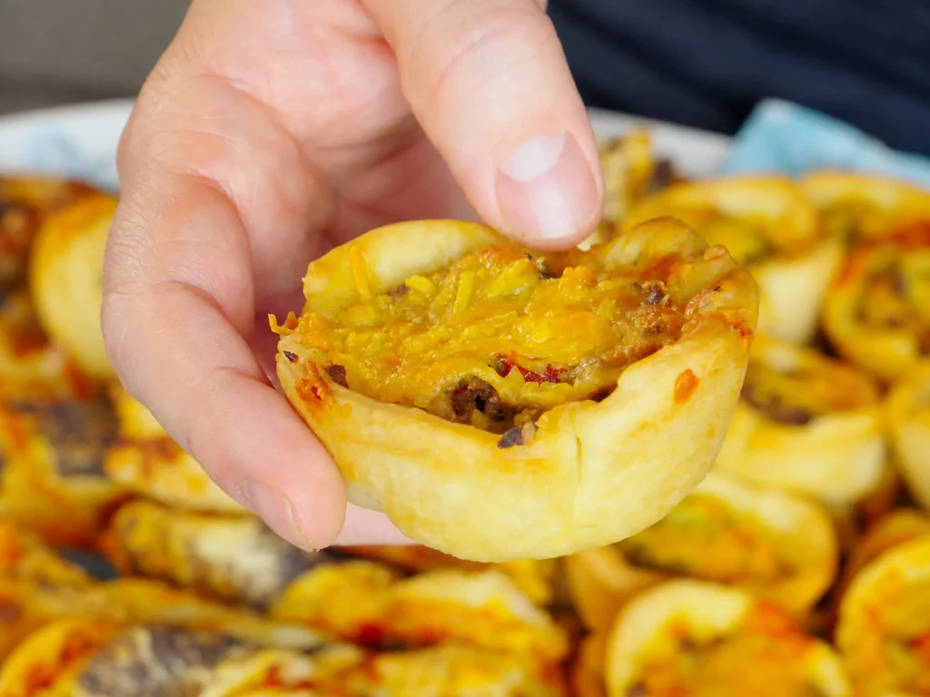 Cheeseburger Muffins mit Hackfleisch-Käse-Füllung, in der Hand gehalten