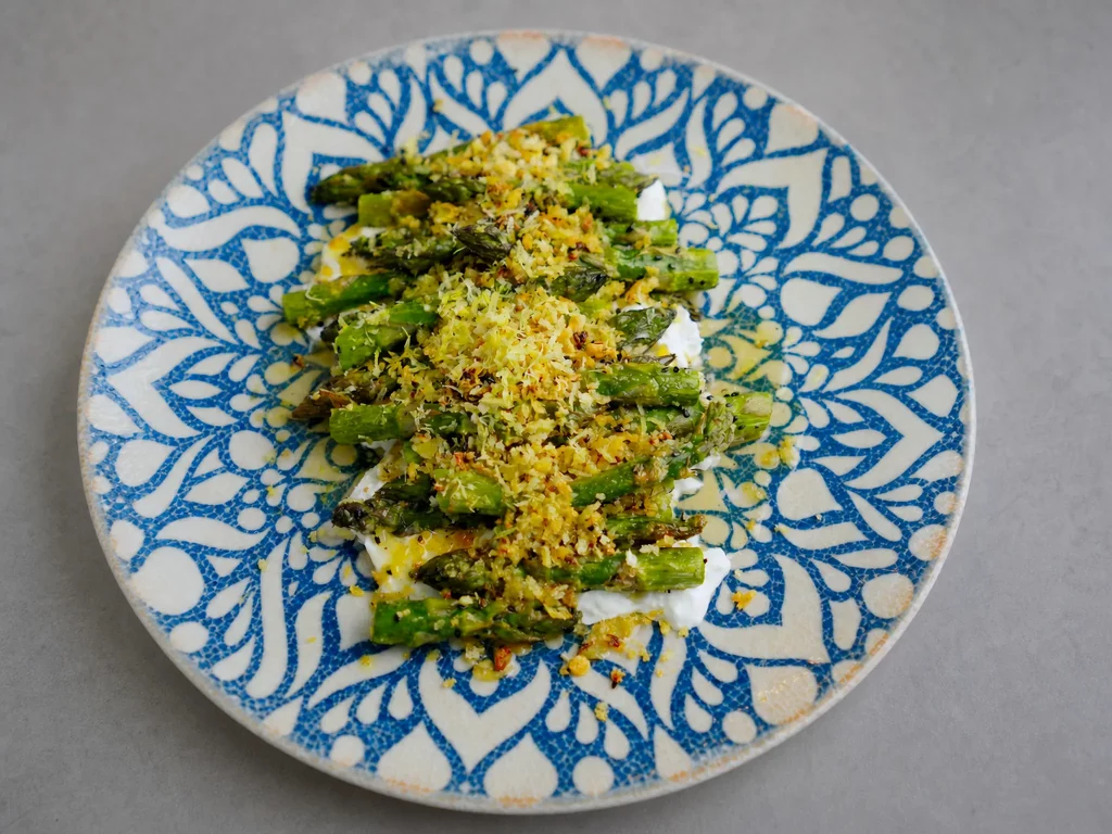 Gebackener grüner Spargel auf cremiger Burrata mit goldenem Panko-Crunch, Zitronenzeste und Chiliflocken
