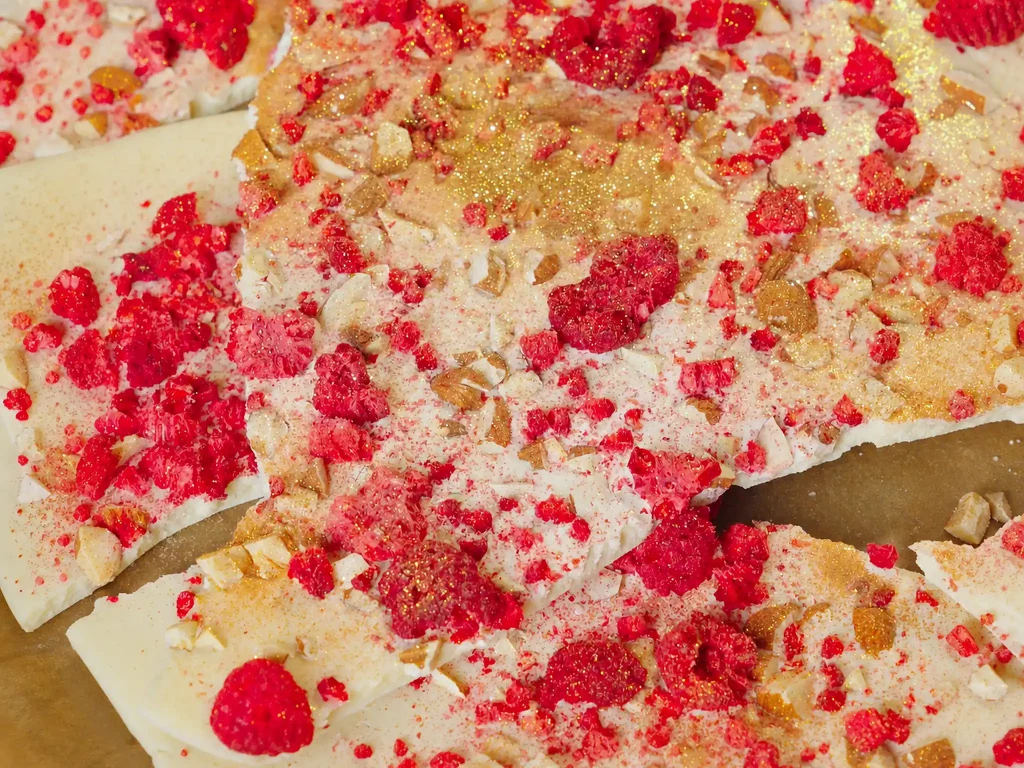 Himbeer-Gold Bruchschokolade – weiße Schokoladenstücke mit gefriergetrockneten Himbeeren, Mandeln und Goldstaub