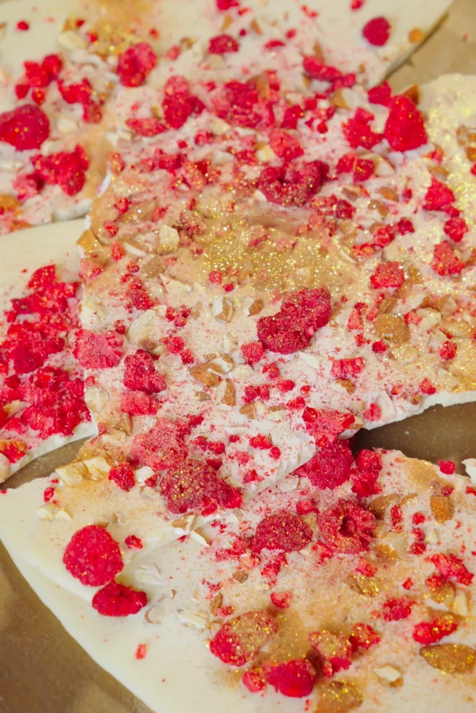 Himbeer-Gold Bruchschokolade in Stücken, mit Himbeeren, Mandeln und Goldstaub bestreut