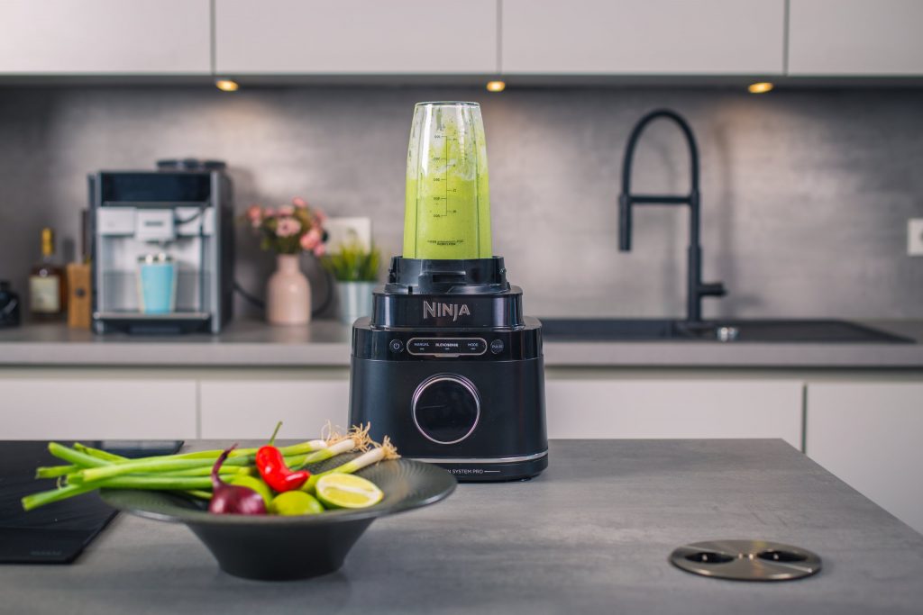 Standmixer mit grünem Smoothie auf der Kücheninsel