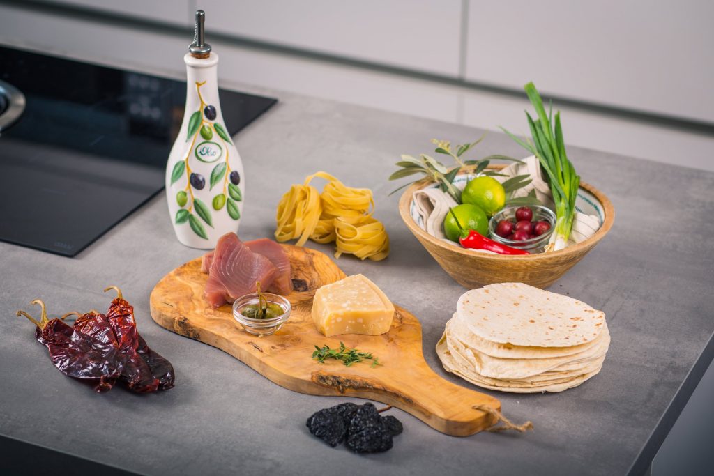 Zutaten auf Olivenholzbrett: Thunfisch, Parmesan, Kapern, Tortillas
