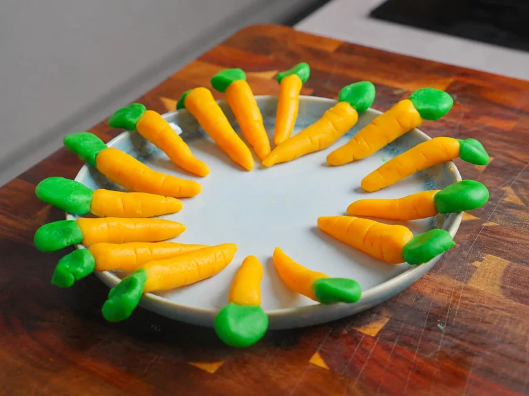 Marzipan-Karotten – kleine essbare Deko-Karotten aus Marzipan, auf einem Teller