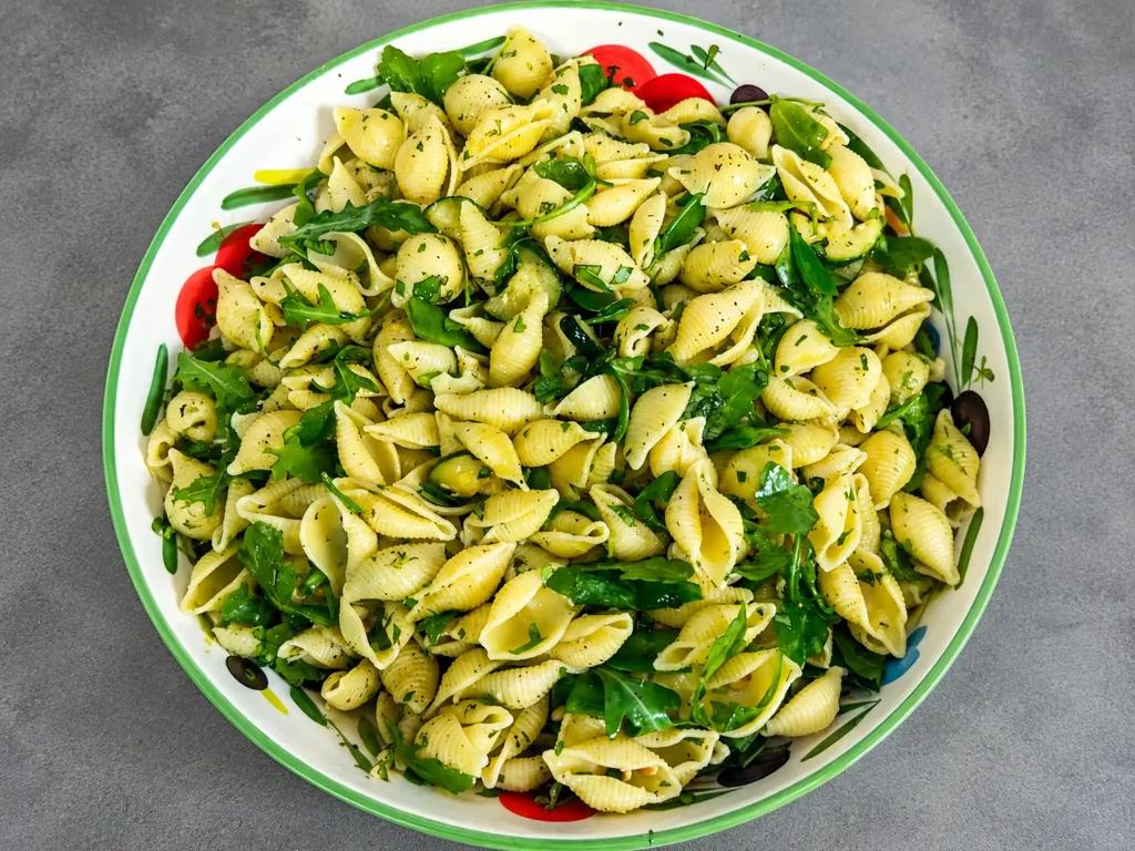 Grüner Nudel Kräuter Salat – Muschelnudeln mit Rucola, Zucchini und frischen Kräutern in einer Schüssel, von oben