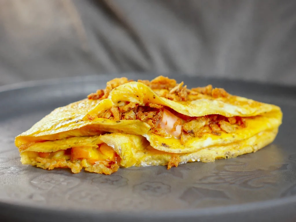 Omelette-Wrap im IKEA Hot Dog-Style mit Röstzwiebeln und geschmolzenem Käse, aufgeschnitten