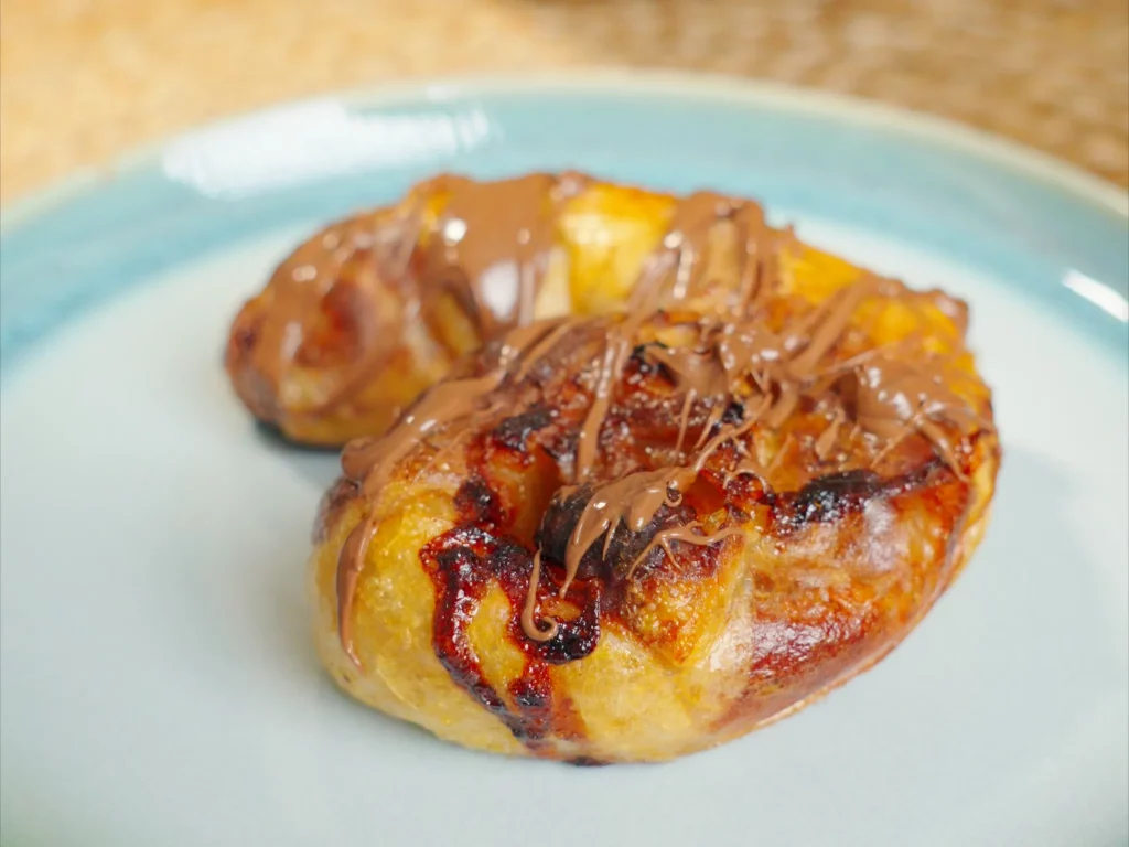 Reispapier Bananen-Börek mit Schokoladensauce beträufelt, auf türkisem Teller