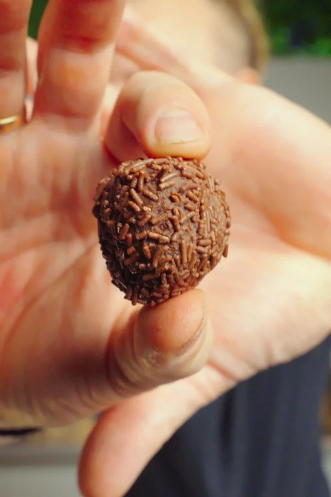 Rum-Kugel mit Schokostreuseln, Nahaufnahme in der Hand