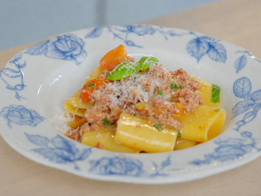 Salsiccia Pasta – Paccheri mit Salsiccia-Ragout, Kirschtomaten und Pecorino auf blau-weißem Teller