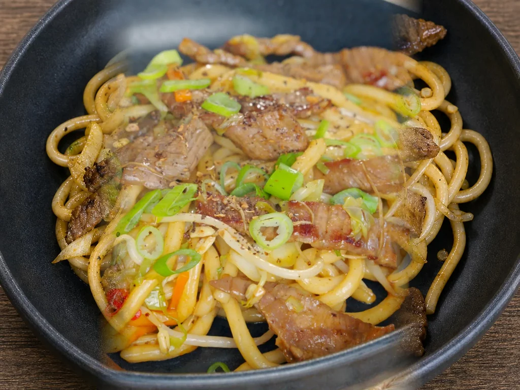 Szechuan Udon Nudeln mit zartem Rindfleisch und Gemüse aus dem Wok