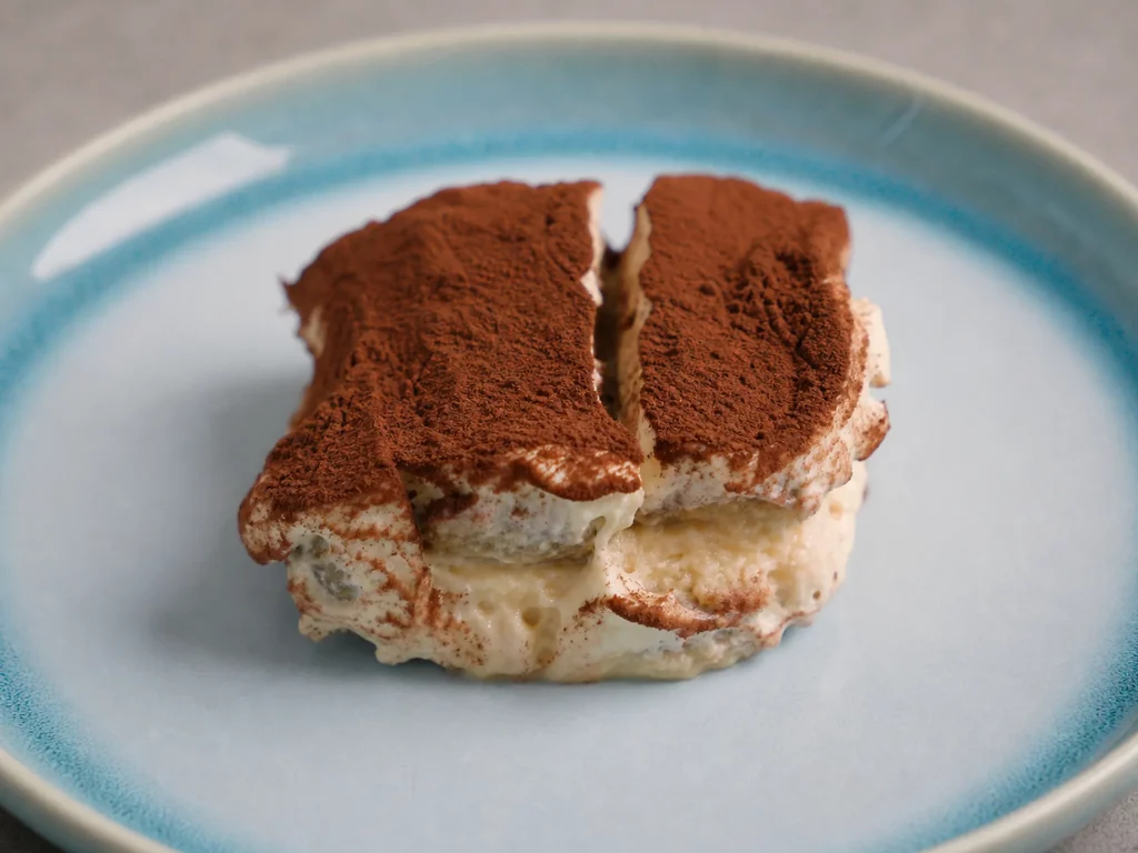 Tiramisu – Stück Tiramisu mit Kakaopulver bestäubt, von der Seite